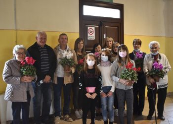 Nonni festeggiati dai loro nipoti con un fiore