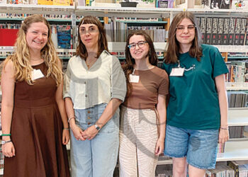 Tre ragazze “tra gli scaffali” della biblioteca “Baccolo”